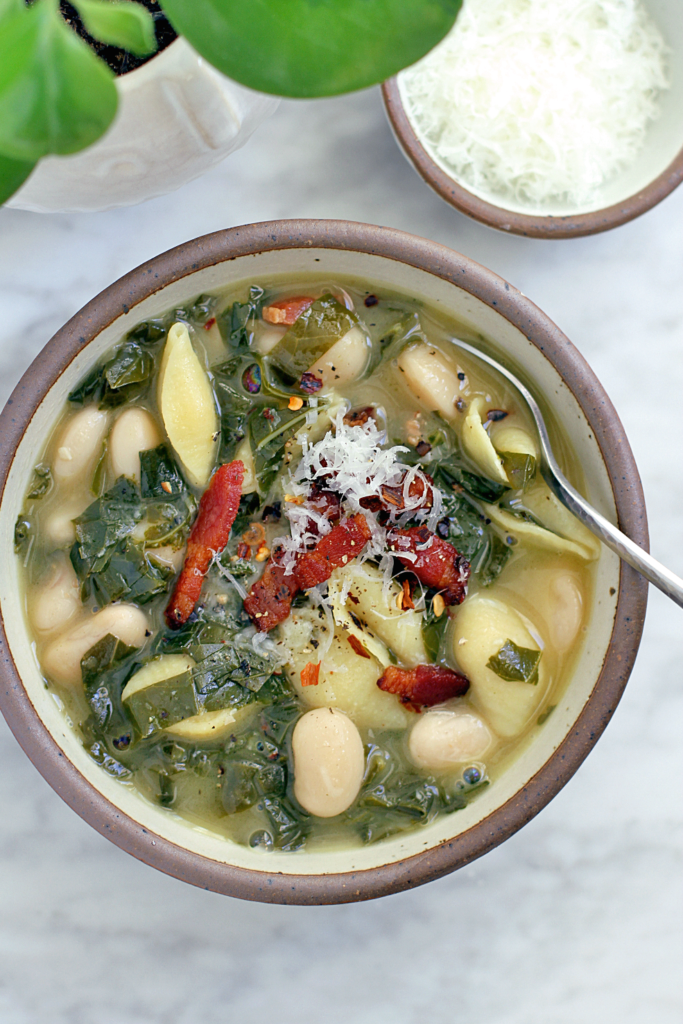 Close-up image of pasta with bacon, greens and Italian butter beans.